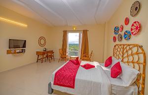 a bedroom with a large bed with red pillows at Hotel SRM Grandeurs in Tudiyalūr