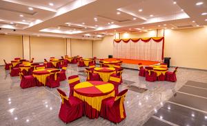 a conference room with tables and chairs and a screen at Hotel SRM Grandeurs in Tudiyalūr +6 photos