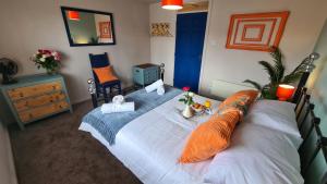 a bedroom with a large white bed with orange pillows at The Kingfisher, by Spires Accommodation a great place to stay for Drayton Manor Park and The NEC in Kingsbury