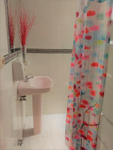 baño con lavabo y cortina de ducha en SevillaDream en Sevilla