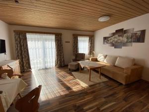 ein Wohnzimmer mit einem Sofa und einem Tisch in der Unterkunft Pension Wörndl in Fuschl am See