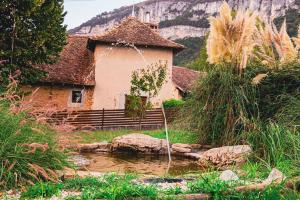 a building with a pond in front of a house at Dépendance chaleureuse et calme in Champagneux