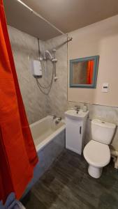 a bathroom with a toilet and a tub and a sink at The Kingfisher, by Spires Accommodation a great place to stay for Drayton Manor Park and The NEC in Kingsbury