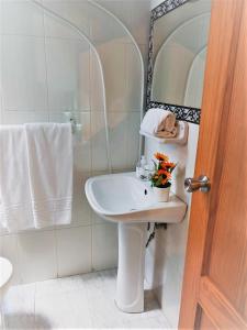 Baño blanco con lavabo y espejo en SevillaDream en Sevilla