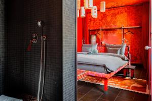 a red bedroom with a bed and a shower at 25hours Hotel Florence Piazza San Paolino in Florence