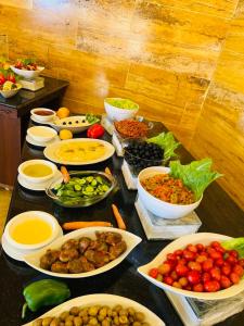 a table topped with bowls of different types of food at Esperanza Petra in Wadi Musa