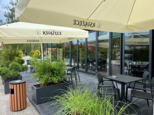 an outdoor patio with tables and chairs and umbrellas at BURSZTYN - BERNSTEIN SPA & Wellness in Dąbki