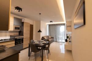 eine Küche und ein Wohnzimmer mit einem Tisch und Stühlen in der Unterkunft Lovely Modern 1 Bedroom Apartment in San Gwann in San Ġwann
