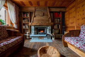 a living room with a fireplace and wooden walls at Hotel Lo Scoiattolo in Gressoney-la-Trinité
