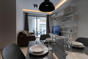 uma sala de jantar com uma mesa de vidro e cadeiras em Lovely Modern 1 Bedroom Apartment in San Gwann em San Ġwann
