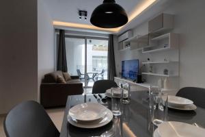 a dining room with a glass table and chairs at Lovely Modern 1 Bedroom Apartment in San Gwann in San Ġwann