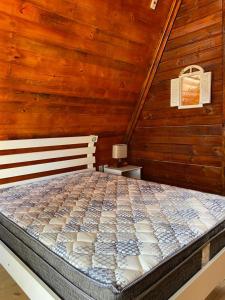 a bedroom with a bed in a wooden wall at Pousada Haras Fazenda Jamaica in Mairinque