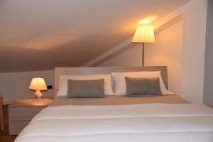 a bedroom with a bed with two pillows and a lamp at Appartamento Ottoz Aosta in Aosta