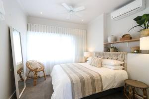 a white bedroom with a bed and a window at The Number Collection 5103 in Cape Town