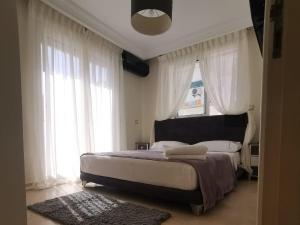 een slaapkamer met een groot bed met witte gordijnen bij Dior D'Anfa in Casablanca