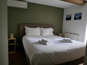 1 dormitorio con 1 cama con toallas en Auberge Trabenia, en Ascain