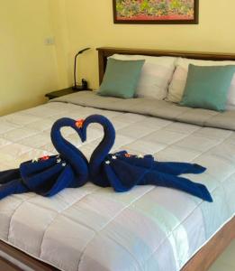 Una cama con dos cintas azules en forma de corazón en Sunanta Bungalow en Ko Lanta