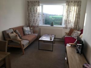 a living room with a couch and a window at Simla Bungalow, Tetney in Tetney