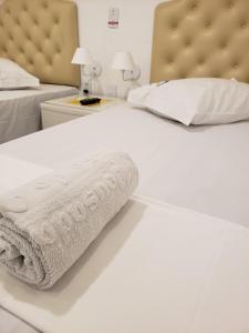 a bed with two white towels on top of it at Pousada Dragao Do Mar in Fortaleza