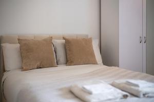 Una cama blanca con dos toallas encima. en Aryas Apartments London en Edgware