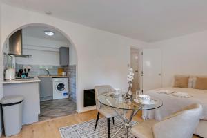a kitchen and a living room with a table and chairs at Aryas Apartments London in Edgware