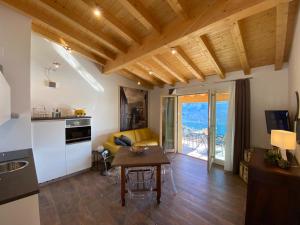 a kitchen and living room with a table and a couch at La Terrazza sul Lago, GTSGroup in Tignale