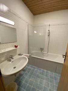 a bathroom with a sink and a bath tub and a sink at Pension Wörndl in Fuschl am See