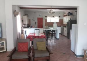 a kitchen and living room with a table and chairs at Seagulls Nest in Port Edward