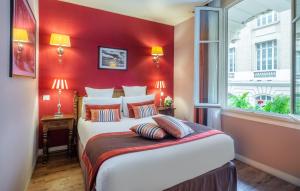 een slaapkamer met een groot bed met een rode muur bij Hotel Trianon Rive Gauche in Parijs