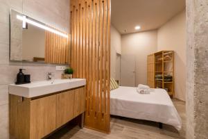 een badkamer met een wastafel en een bed erin bij Art Lofts Gardens in Valencia