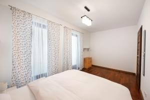 1 dormitorio con cama blanca y ventana en Malborska Lovely Apartment, en Varsovia