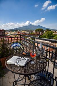 einen Tisch mit einem Glas Wein auf dem Balkon in der Unterkunft Hotel Palma in Pompei