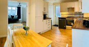 a kitchen with a table with a vase of flowers on it at Homely Detached 3 bedroom house near Sheffield in Rotherham +24 photos