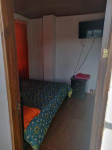 a small bedroom with a bed and a television at Eliseo Tota Balcón in Tota