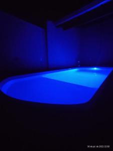 a blue bath tub in a dark room at Recanto Lili in Olímpia