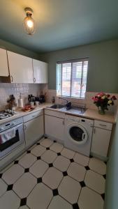 a kitchen with a sink and a washing machine at The Farrier's by Spires Accommodation A convenient place to stay for exploring Cannock Chase in Hednesford