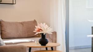 wazon z kwiatem na stole w salonie w obiekcie Modern Adora Apartment w mieście Malinska