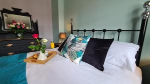 a bed with a wooden tray with a pillow and flowers at The Farrier's 3 bedroom comfy and cosy bolt hold close to Cannock town centre in Hednesford