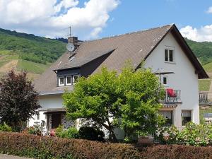 a white house with a clock on top of it at Schorn³ Appartements in Zell an der Mosel