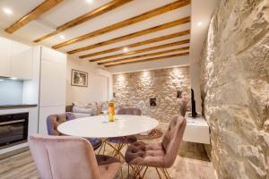 a room with a table and chairs and a stone wall at Old Stone House GP in Podstrana