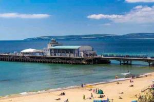 a pier on a beach with people on the beach at 1 Bedroom self contained apartment in Christchurch in Winkton