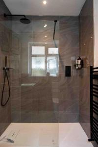 a shower with a glass door in a bathroom at 1 Bedroom self contained apartment in Christchurch in Winkton