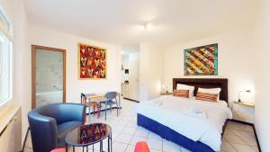 谢尔Spacious studio in a nice area in Sierre的一间卧室，配有一张床、一张桌子和几把椅子