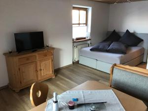 Habitación pequeña con cama y TV. en Haus am Dürrach, en Reit im Winkl