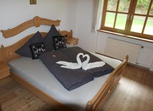 a bedroom with a bed with two swans on it at Haus am Dürrach in Reit im Winkl