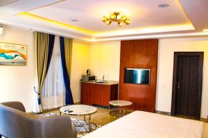 uma sala de estar com um sofá, uma mesa e uma televisão em Fahrenheit Apartments em Abuja