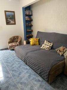 Cama en habitación con sofá y silla en Casa agradável com pequena piscina !, en Águas de Lindóia