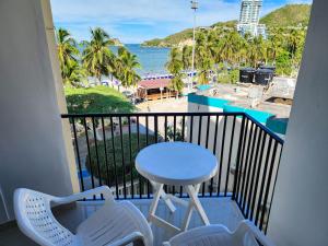 balcón con mesa, sillas y vistas al océano en Apartamento frente a la playa 5B - By Bedviajes, en Santa Marta