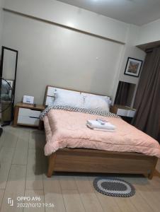 een slaapkamer met een groot bed en een roze deken bij Rqui CondoTel Near Airport in Manilla