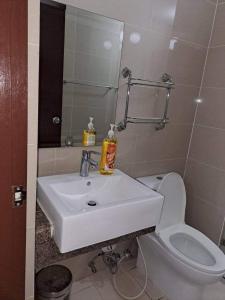 een badkamer met een witte wastafel en een toilet bij Rqui CondoTel Near Airport in Manilla